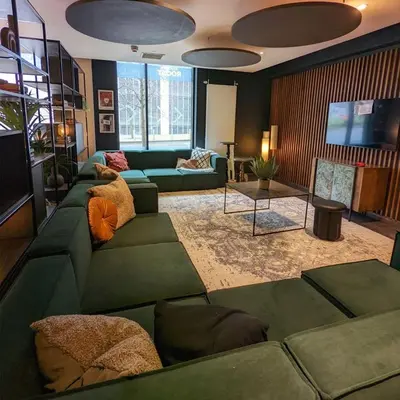 a living room with green couches and a television at Student Only Merchant Studios in Glasgow in Glasgow