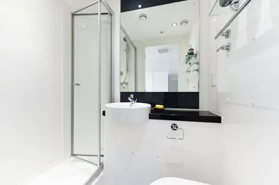 a white bathroom with a sink and a shower at Student Only Merchant Studios in Glasgow in Glasgow