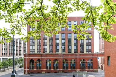 a brick building on a city street with trees at Student Only Merchant Studios in Glasgow in Glasgow
