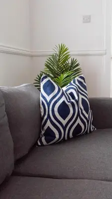 a blue and white pillow sitting on a couch at 3 BDR House At Caledonia Luxe Stays Short Lets & Serviced Accommodation Tillicoultry in Tillicoultry