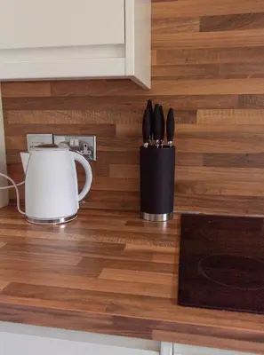 a kitchen counter with two utensils in a holder at 1 BDR Apt At Caledonia Luxe Stays Short Lets & Serviced Accommodation Paisley in Paisley