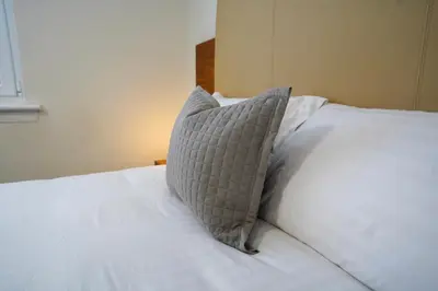 a white bed with a pillow on top of it at Hardgate House Hotel in Clydebank