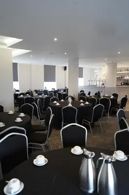 a conference room with black tables and chairs at Hardgate House Hotel in Clydebank
