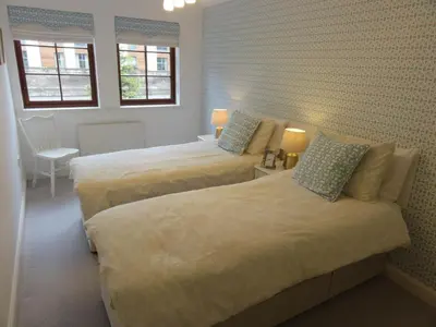 two beds in a room with two windows at Orchard Brae in Edinburgh