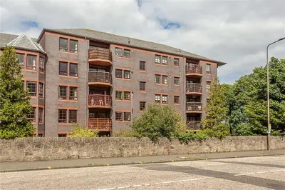a large brick building with balconies on a street at Orchard Brae in Edinburgh