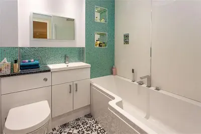 a bathroom with a tub and a toilet and a sink at Orchard Brae in Edinburgh