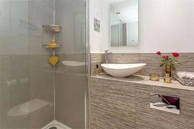 a bathroom with a glass shower and a sink at Orchard Brae in Edinburgh