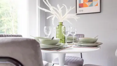 a table with plates and glasses and a vase at Croftspar House in Glasgow