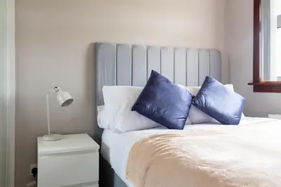 a bed with two blue pillows on top of it at Croftspar House in Glasgow