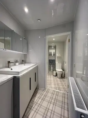 a white bathroom with two sinks and a toilet at Spacious boutique two-bedroom apartment next to the castle in Edinburgh