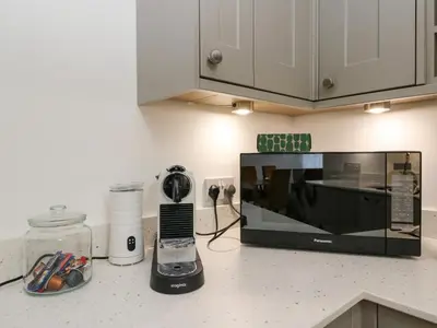 a kitchen counter with a microwave and a phone on it at Kalipé in Aberfeldy