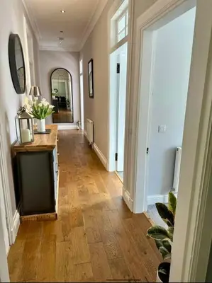 a hallway of a home with a wooden floor at Beautiful spacious apartment in town centre in Oban