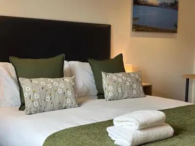 a bed with white sheets and pillows on it at The Gîte in the Highlands in Acharra