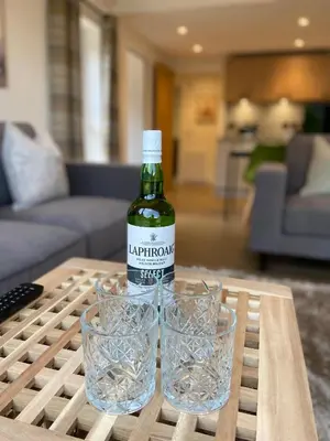a bottle of wine and two glasses on a table at The Gîte in the Highlands in Acharra