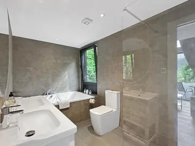 a bathroom with a tub and a toilet and a sink at Aos Sí - Wellness - Jacuzzi - Lodges in Ballachulish