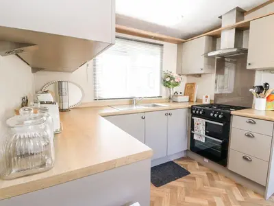 a kitchen with white cabinets and a black stove top oven at Saorsa in Crieff