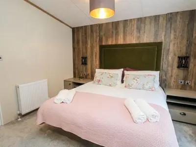 a bedroom with a large bed with towels on it at Saorsa in Crieff