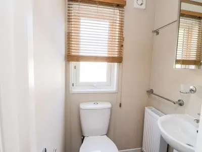 a bathroom with a toilet and a sink and a window at Saorsa in Crieff