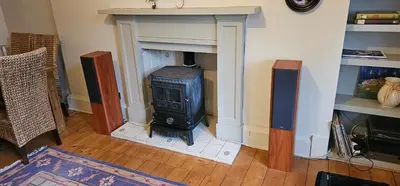 a living room with a wood stove in a fireplace at Snug - Macushla Apartment in Helensburgh