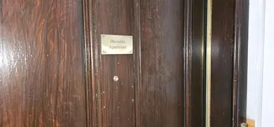 a wooden door with a sign on it at Snug - Macushla Apartment in Helensburgh