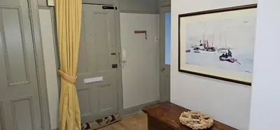 a hallway with a painting on the wall and a curtain at Snug - Macushla Apartment in Helensburgh