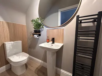 a bathroom with a toilet and a sink and a mirror at Longbank Luxury Lets in Ayr