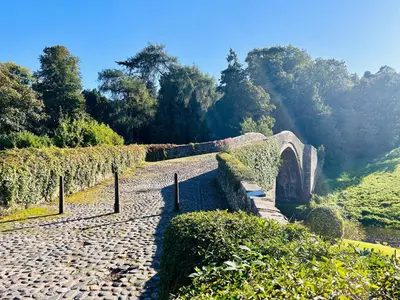 a stone path next to a bridge and a river at Longbank Luxury Lets in Ayr