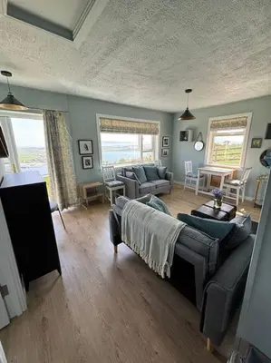 a living room with a couch and a table at Stunning Rathlin cottage in Rathlin Island