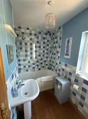 a bathroom with a sink and a tub and a toilet at Beachside House Rathlin Island in Rathlin Island