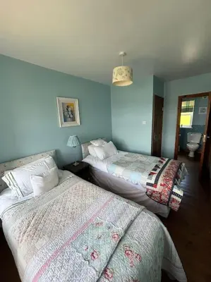 two beds in a room with blue walls at Beachside House Rathlin Island in Rathlin Island