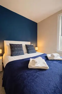 a bedroom with a large bed with towels on it at Register House Family or Contractor 4bed with Garden Driveway in Bellshill