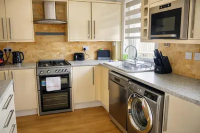 a kitchen with a dishwasher and a washer at Register House Family or Contractor 4bed with Garden Driveway in Bellshill
