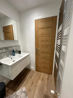 a bathroom with a sink and a wooden door at Highland Hideaway in Fort William