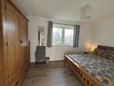 a bedroom with a bed with a dresser and a window at Highland Hideaway in Fort William