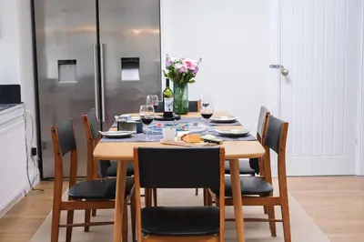 a dining room table with chairs and wine glasses at Lang Toon House - 3 bedrooms in Auchterarder