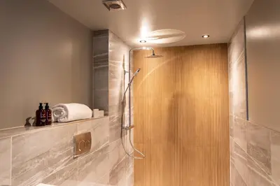 a shower with a glass door in a bathroom at DeiRa Hotel & Apartments in Prestwick