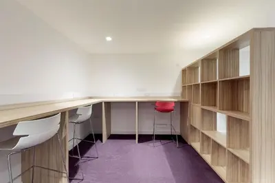 an office with wooden shelves and a desk with stools at Abodus St James Glasgow in Glasgow