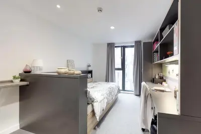 a small bedroom with a bed and a desk at Abodus St James Glasgow in Glasgow