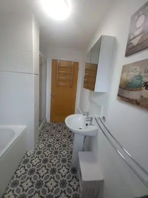 a white bathroom with a sink and a bath tub at Idyllic Waterside Penthouse in Callander