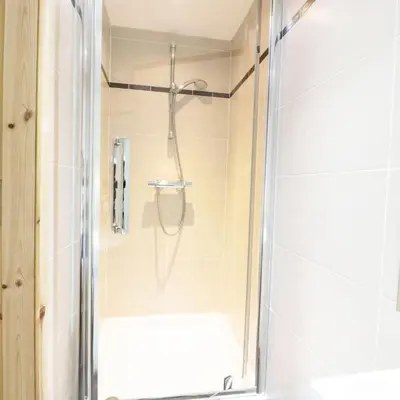 a shower with a glass door in a bathroom at Cnocachanach Cottage in Tarbert