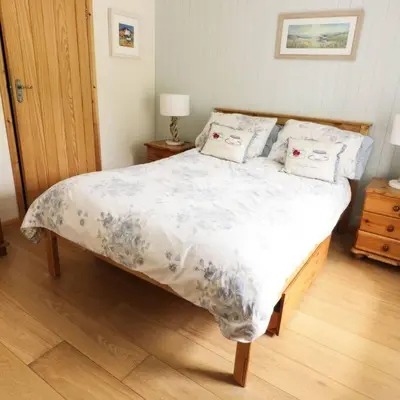 a bedroom with a large bed with pillows on it at Cnocachanach Cottage in Tarbert