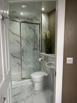 a bathroom with a toilet and a shower and a sink at Peel House Bed and Breakfast in Girvan