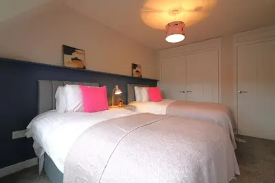 two beds sitting next to each other in a bedroom at Signature - Martin House in Old Monkland