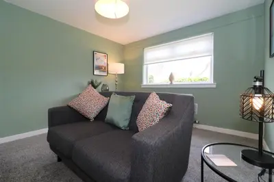 a living room with a couch and a window at Signature - Martin House in Old Monkland