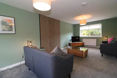 a living room with a couch and a television at Signature - Martin House in Old Monkland