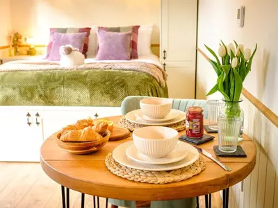 a table with plates of food on it with a bed at Lintmill Lodges - Thistle Shepherds Hut in Sorn