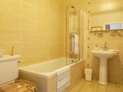 a bathroom with a tub and a toilet and a sink at Tarandoun Cottage in Helensburgh