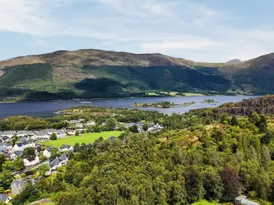 an aerial view of a town with a river and mountains at Pine Marten Cottage in Ballachulish