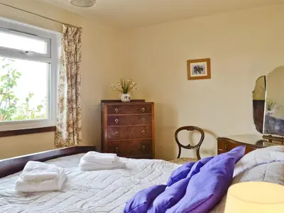a bedroom with a bed and a window and a dresser at Crubisdale in Blairmore