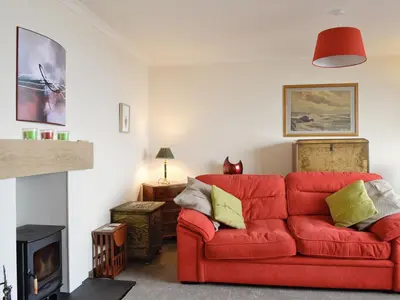 a red couch in a living room with a fire place at Crubisdale in Blairmore